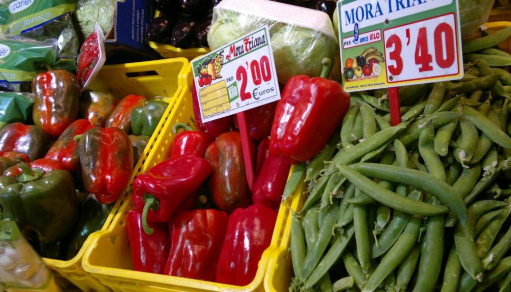 Gemüse an einem Gemüsestand. Zu sehen sind rote Paprika und grüne Bohnen
